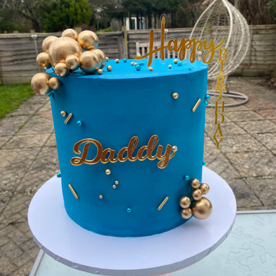 Deep blue cake with gold ball decorations