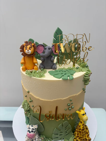 Jungle-themed birthday cake with animal figurines and decorations on a white background