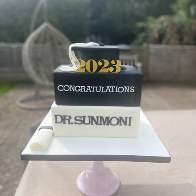 Graduation books and cap cake