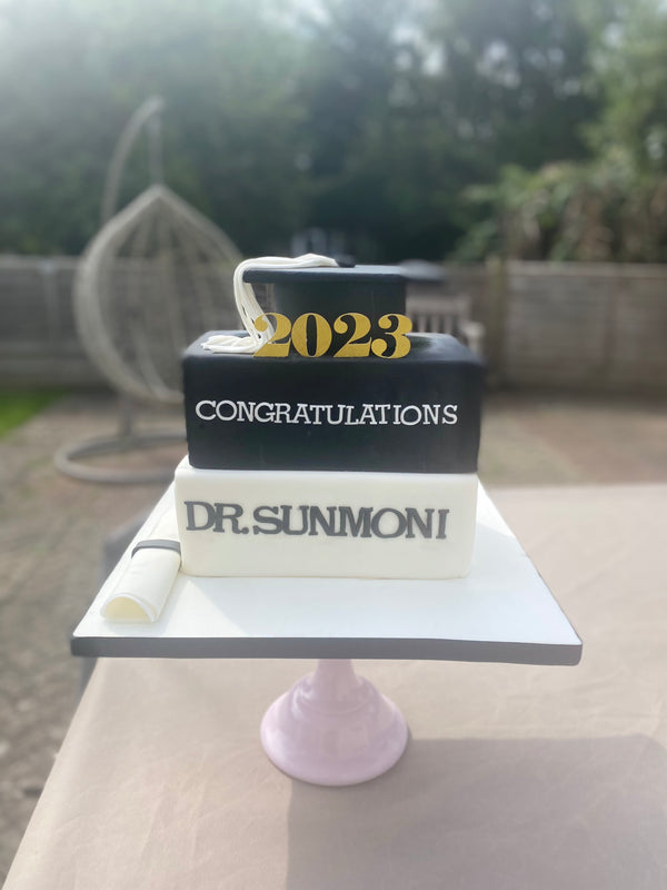 Graduation books and cap cake