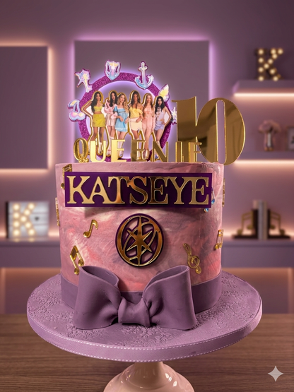 Decorative cake with 'Katseye' and 'Queen' text, featuring a bow and colorful design.